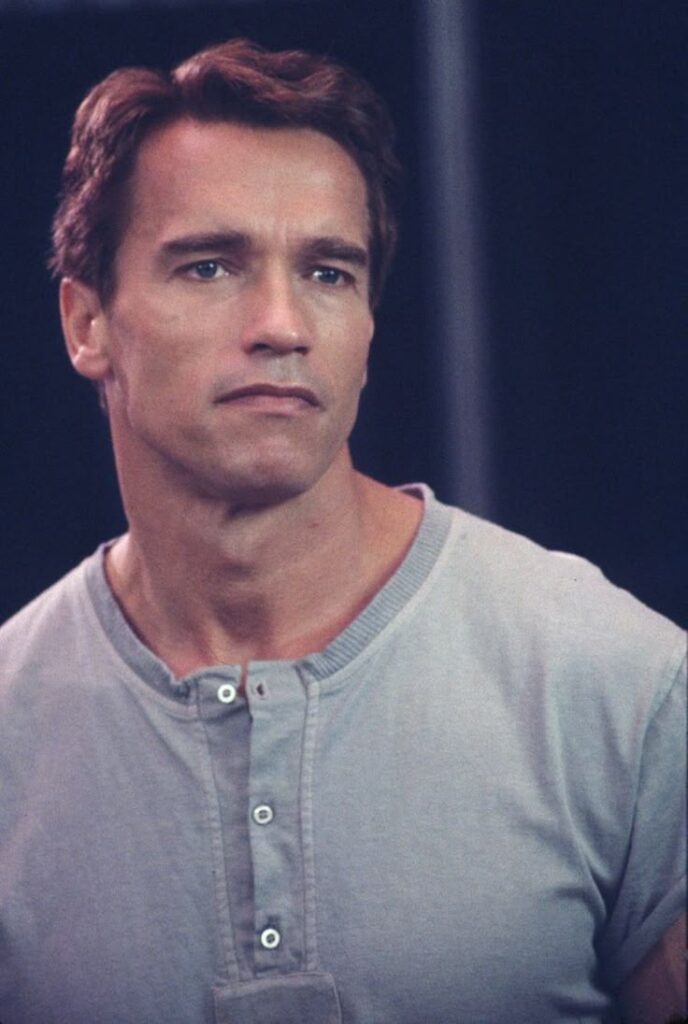 A robust portrait of actor and former governor Arnold Schwarzenegger, with a confident, friendly expression in a casual blazer.