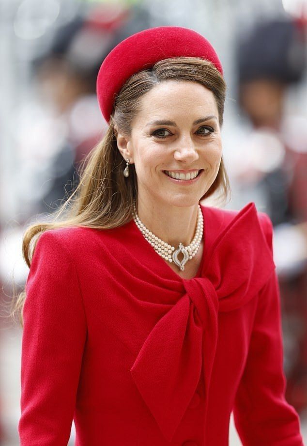 A poised portrait of Catherine, Princess of Wales, smiling warmly with styled brown hair, wearing an elegant, brightly colored tailored dress.