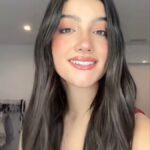 ​A bright, youthful headshot of digital creator Charli D'Amelio, smiling warmly with styled dark hair and natural makeup.