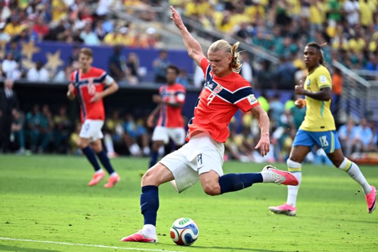 Erling Haaland striking a soccer ball mid-match.
