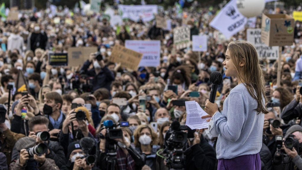 Activist Greta Thunberg speaking passionately at a climate rally