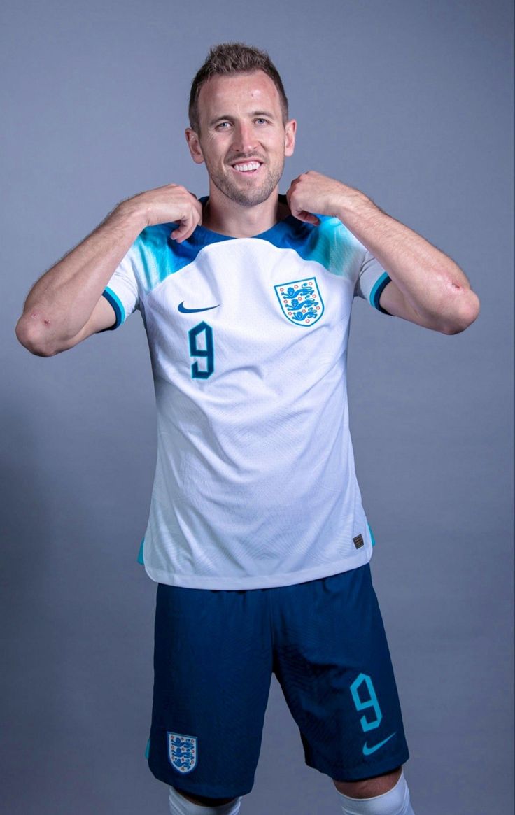 A professional sports portrait of football player Harry Kane in his team uniform, looking forward with a determined smile.