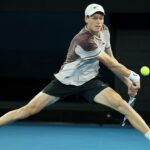 A focused action shot of Jannik Sinner preparing to hit a forehand shot during a professional tennis match.