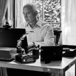 Black and white portrait of young Jeff Bezos in 1994 working at a desk with an early computer in his Bellevue garage setup.