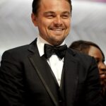Close-up portrait of actor Leonardo DiCaprio smiling at a red carpet event.