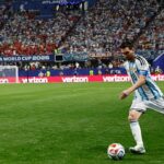 Lionel Messi dribbling a soccer ball during a match.