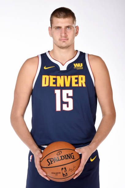 A professional sports portrait of NBA player Nikola Jokić in his team jersey, looking calm and focused.