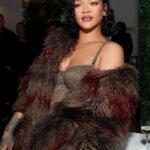 Rihanna posing for a portrait wearing a fashionable outfit.