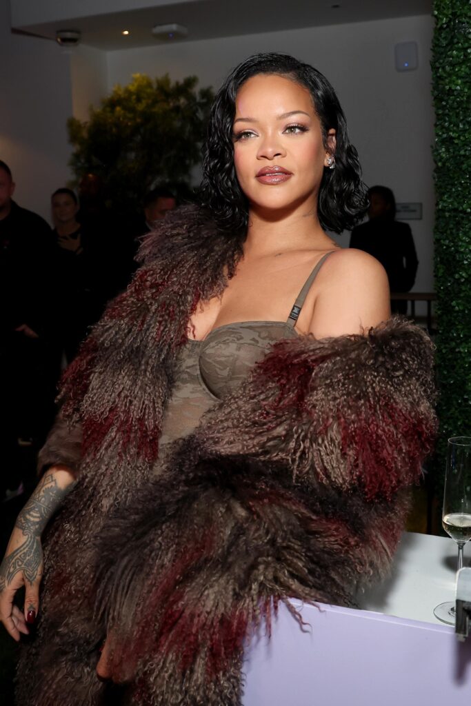 Rihanna posing for a portrait wearing a fashionable outfit.
