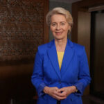 Ursula von der Leyen, President of the European Commission, wearing a blue suit and smiling in a neutral background.