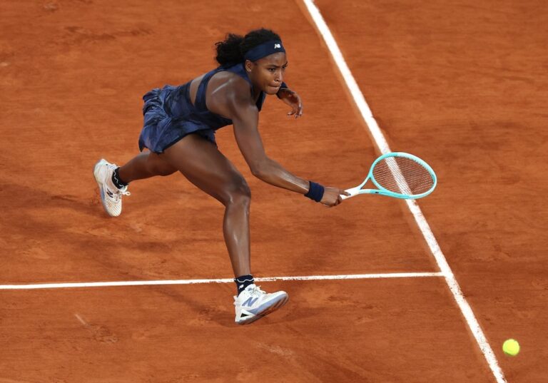 A dynamic photo of tennis star Coco Gauff tracking the ball down the court with intense concentration.