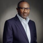 Headshot of Nigerian investor and philanthropist Femi Otedola smiling in modern attire.