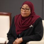Official portrait of Samia Suluhu Hassan, President of Tanzania, wearing a traditional headscarf and blazer.