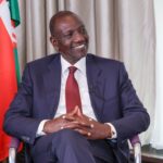 Professional portrait of William Ruto, President of Kenya, smiling in formal attire.